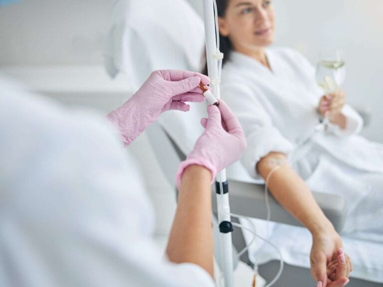 Licensed medical provider administering IV hydration to a patient at home in Phoenix, using hospital-grade supplies and sterile technique.