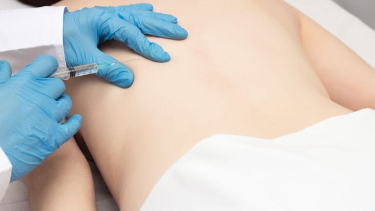 Provider performing a trigger point injection for muscle knot and back pain relief during an at-home visit in Phoenix, Arizona.