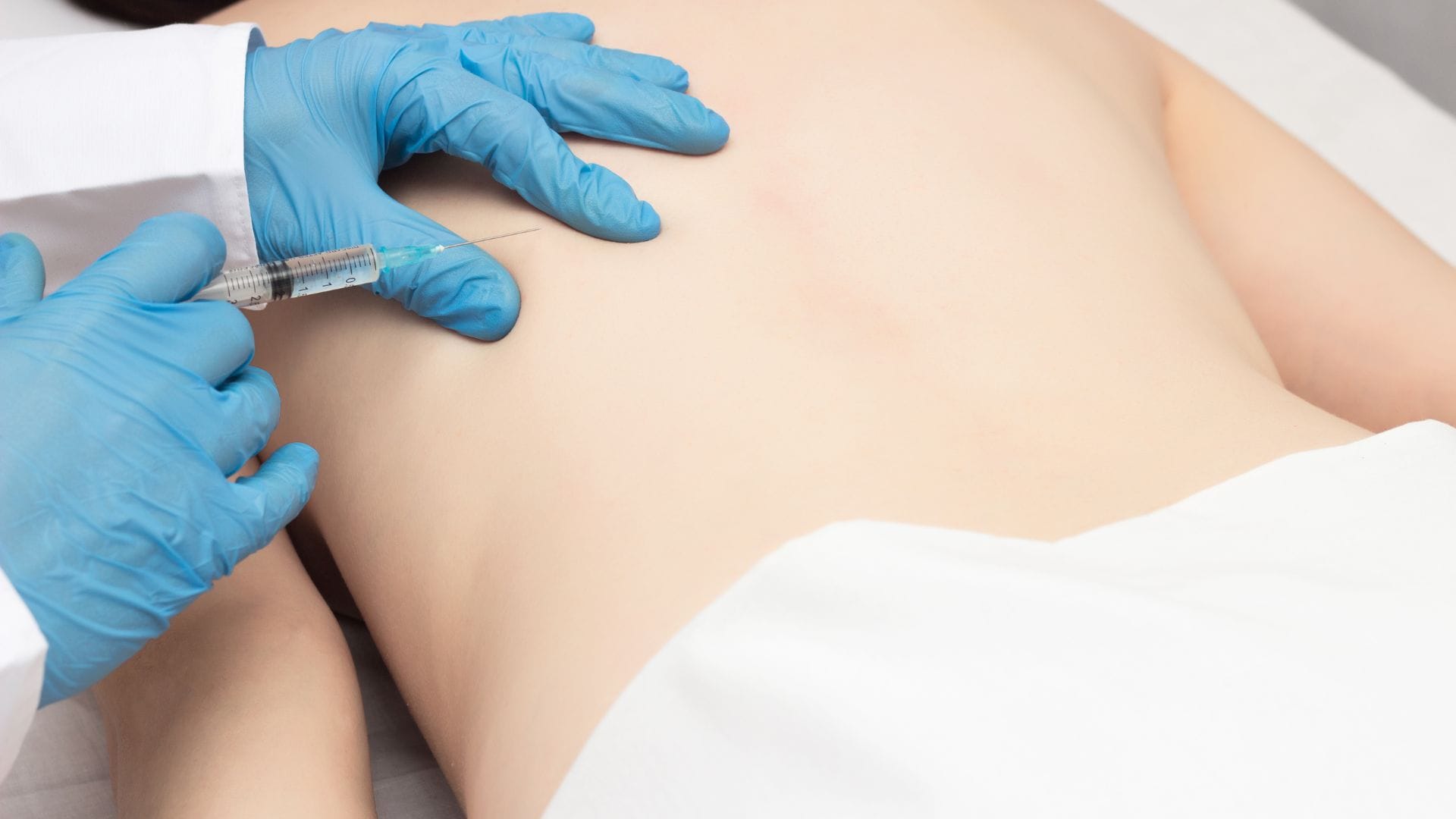 Provider performing a trigger point injection for muscle knot and back pain relief during an at-home visit in Phoenix, Arizona.